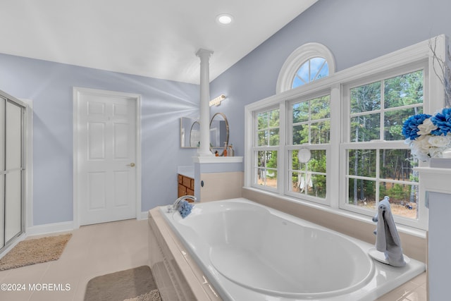 bathroom with tile patterned floors, tiled bath, vanity, and vaulted ceiling