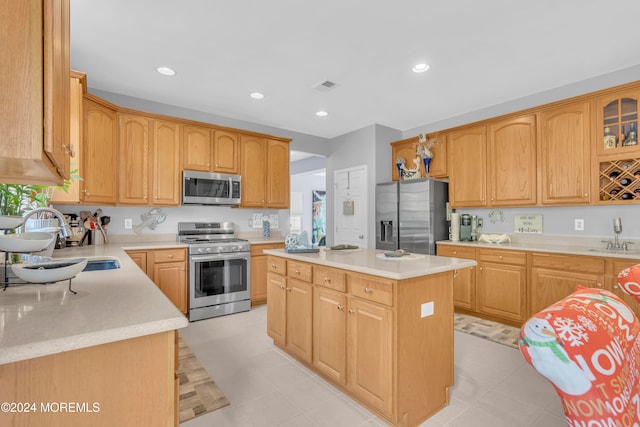 kitchen with appliances with stainless steel finishes, a center island, and sink