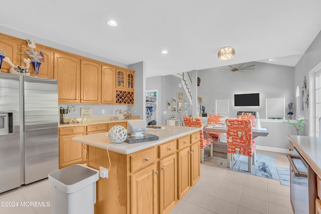 kitchen featuring ceiling fan, a kitchen island, stainless steel fridge with ice dispenser, and light tile patterned floors