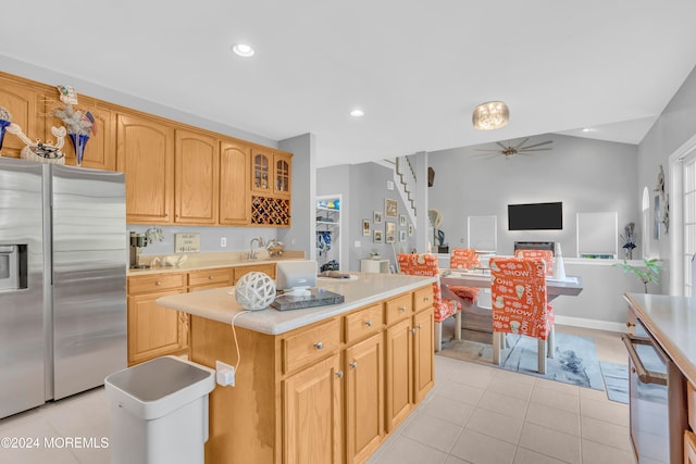 kitchen featuring ceiling fan, light tile patterned floors, a kitchen island, and stainless steel refrigerator with ice dispenser