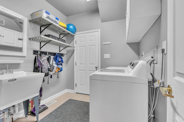 laundry area featuring light tile patterned floors and washing machine and dryer