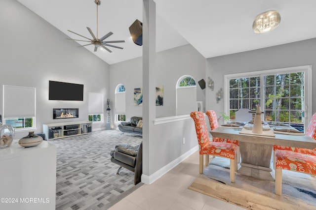 interior space featuring ceiling fan, high vaulted ceiling, and light tile patterned floors