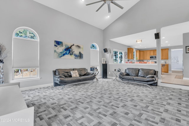 carpeted living room with high vaulted ceiling, a wealth of natural light, and ceiling fan