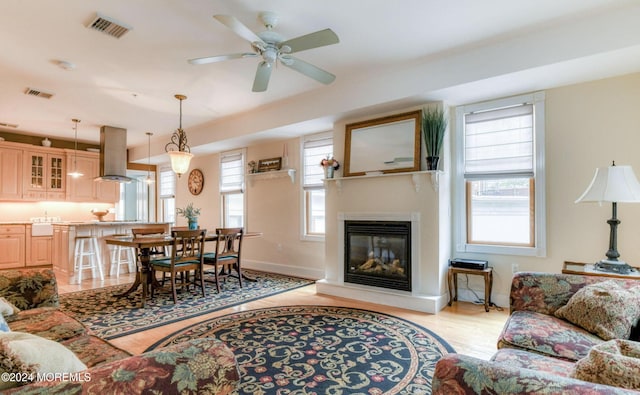 living room featuring light hardwood / wood-style floors, plenty of natural light, and ceiling fan