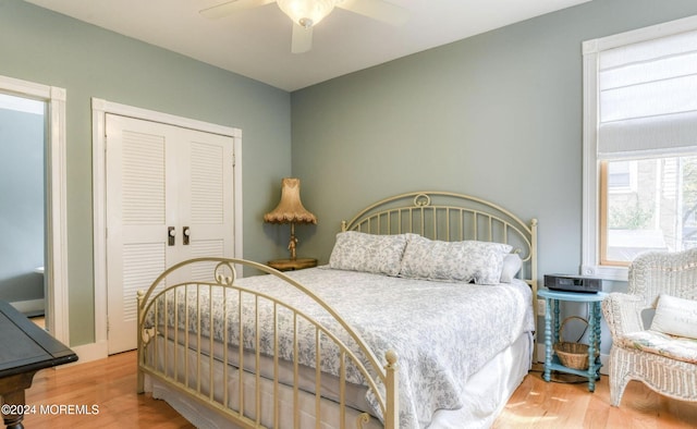 bedroom with ceiling fan, wood-type flooring, and a closet