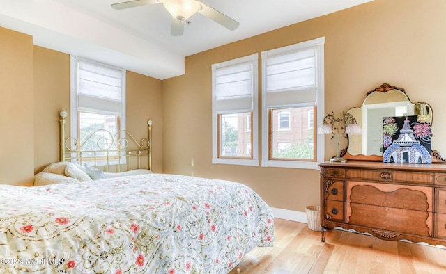 bedroom with multiple windows, ceiling fan, and light hardwood / wood-style floors