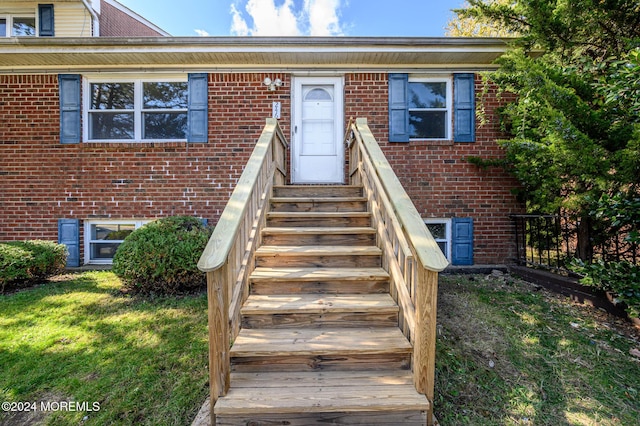 view of exterior entry with a yard