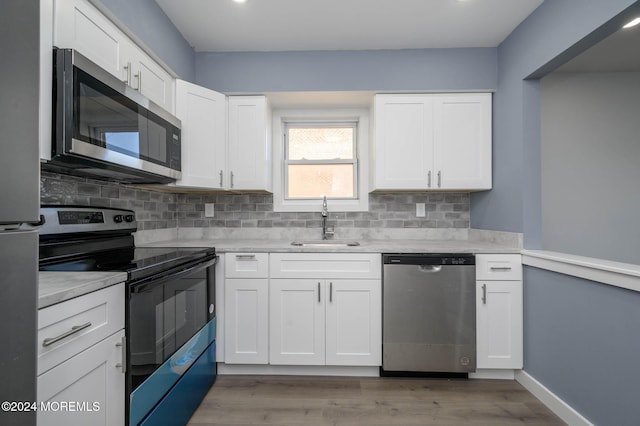 kitchen featuring appliances with stainless steel finishes, white cabinetry, and sink