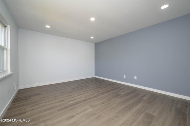 spare room featuring hardwood / wood-style floors and plenty of natural light