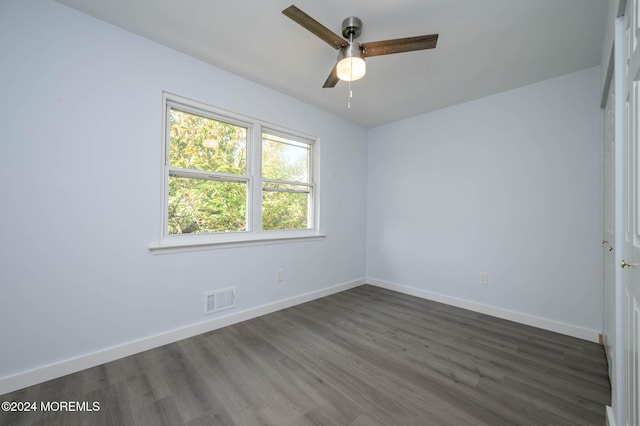 empty room with dark hardwood / wood-style flooring and ceiling fan