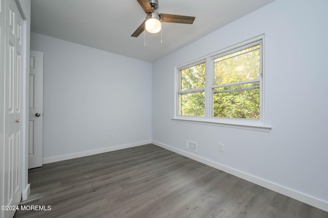 empty room with ceiling fan and dark hardwood / wood-style flooring