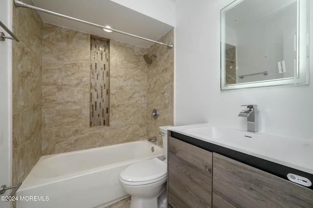 full bathroom featuring vanity, tiled shower / bath combo, and toilet