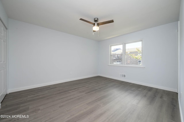 spare room with dark hardwood / wood-style flooring and ceiling fan