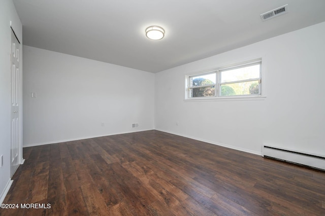 unfurnished room featuring dark hardwood / wood-style floors and a baseboard radiator