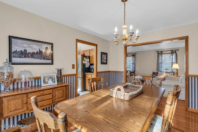 dining area with hardwood / wood-style floors and a notable chandelier