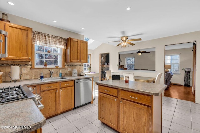 kitchen with appliances with stainless steel finishes, a kitchen island, a wealth of natural light, and sink