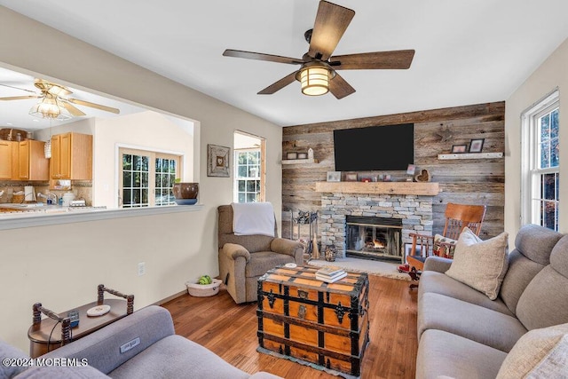 living room with wood walls, a fireplace, and light wood-type flooring