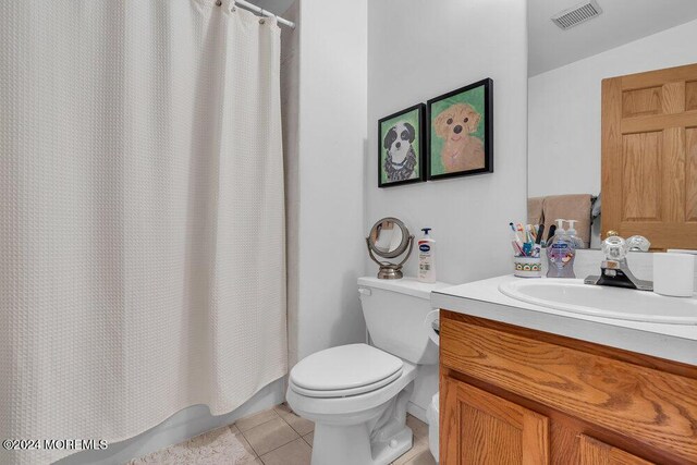 bathroom with tile patterned floors, a shower with curtain, vanity, and toilet