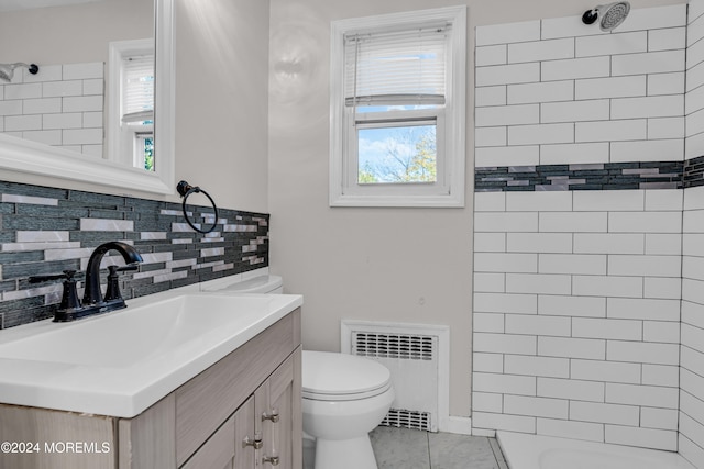 bathroom with tile patterned flooring, radiator heating unit, vanity, and a wealth of natural light