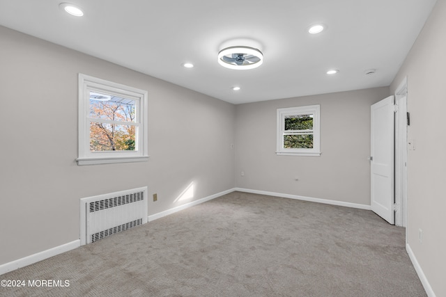 carpeted spare room featuring radiator