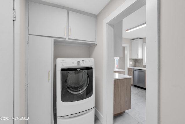 laundry room featuring cabinets and washer / dryer