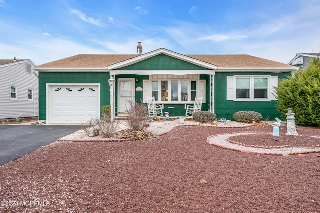 single story home featuring covered porch and a garage