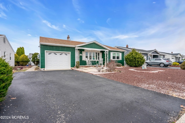 single story home with covered porch and a garage