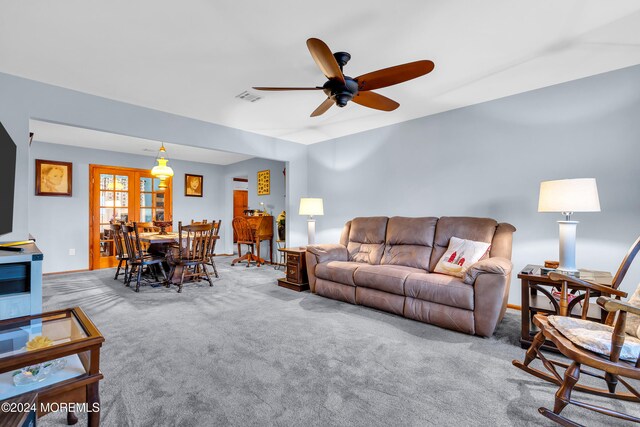 carpeted living room featuring french doors and ceiling fan