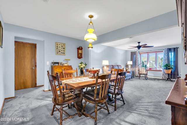 carpeted dining room with ceiling fan