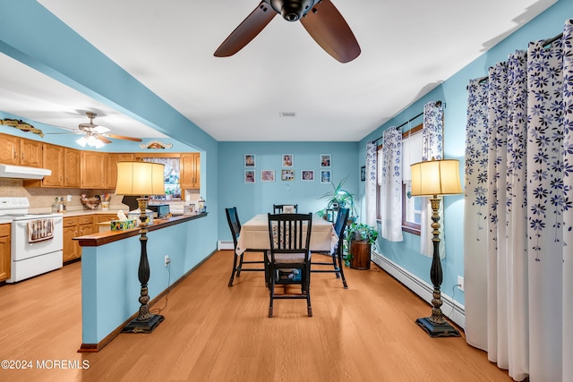 dining space with ceiling fan, light hardwood / wood-style floors, and a baseboard heating unit