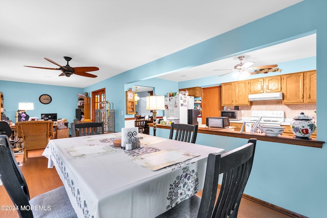 dining space with wood-type flooring and ceiling fan