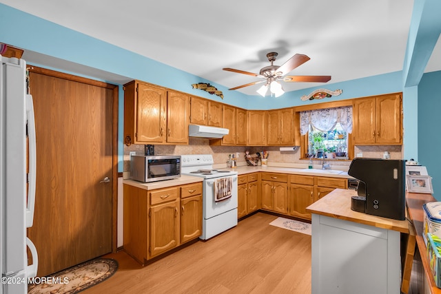 kitchen featuring white appliances, sink, ceiling fan, decorative backsplash, and light hardwood / wood-style floors