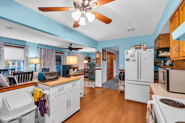 kitchen with white cabinets, white appliances, and light hardwood / wood-style flooring