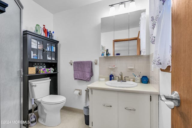 bathroom featuring vanity, toilet, and backsplash