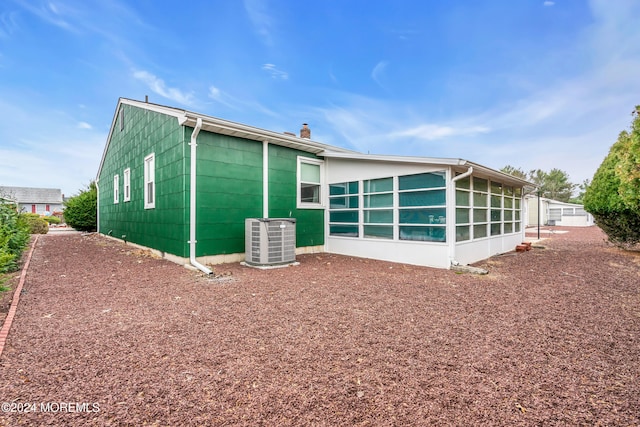 rear view of property featuring cooling unit and a sunroom