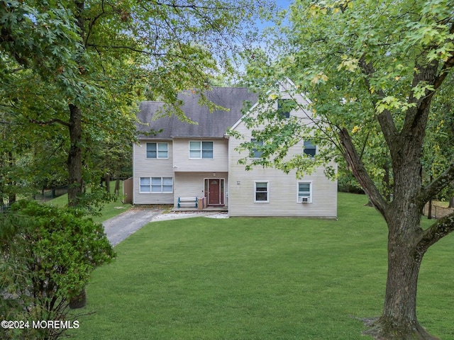 rear view of property featuring a lawn