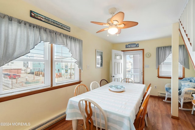 dining space featuring hardwood / wood-style floors, baseboard heating, and a wealth of natural light