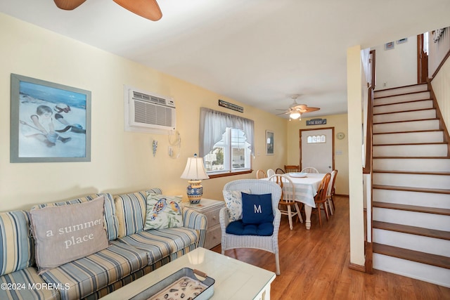 living room featuring hardwood / wood-style flooring, an AC wall unit, and ceiling fan