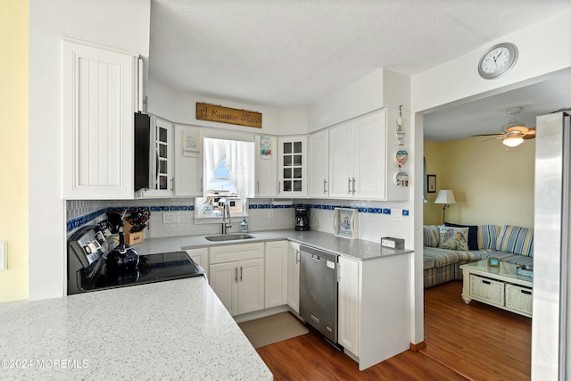 kitchen with sink, dark wood-type flooring, stainless steel appliances, decorative backsplash, and white cabinets