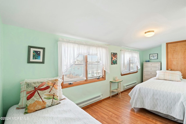 bedroom featuring baseboard heating and wood-type flooring