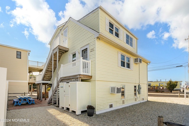 rear view of house with a wall unit AC