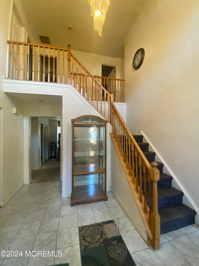 stairs featuring a towering ceiling and an inviting chandelier