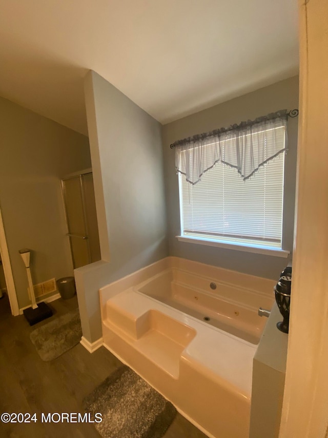 bathroom featuring hardwood / wood-style flooring and shower with separate bathtub