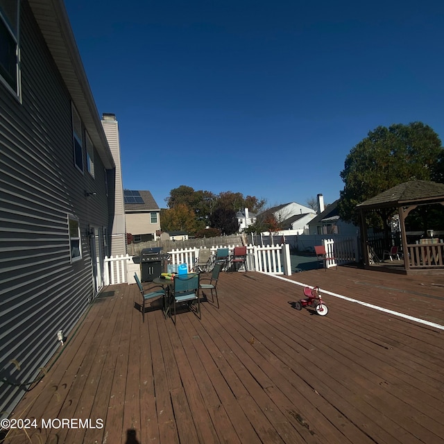 wooden terrace featuring a gazebo and grilling area