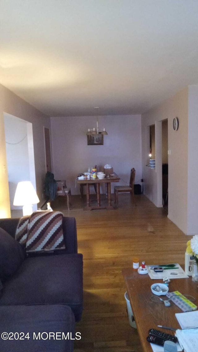 living room with wood-type flooring and a notable chandelier