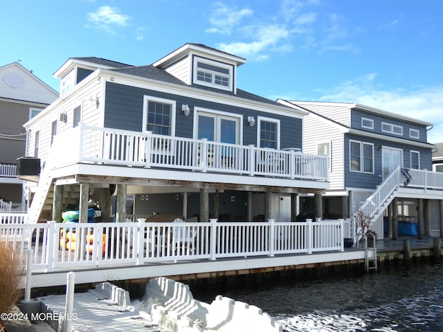 view of front of home with central AC unit and a deck with water view