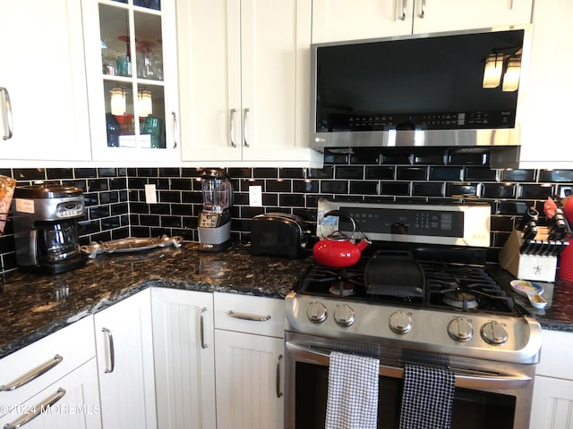 kitchen with backsplash, white cabinetry, and stainless steel appliances