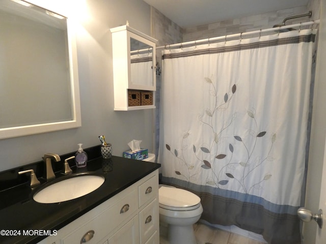 bathroom featuring vanity, toilet, and walk in shower