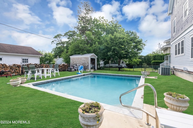 view of swimming pool with a lawn, central AC unit, and an outdoor structure