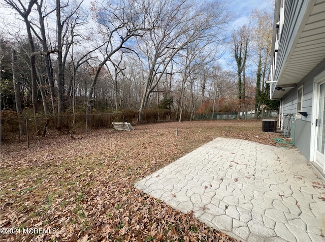 view of yard with central AC and a patio